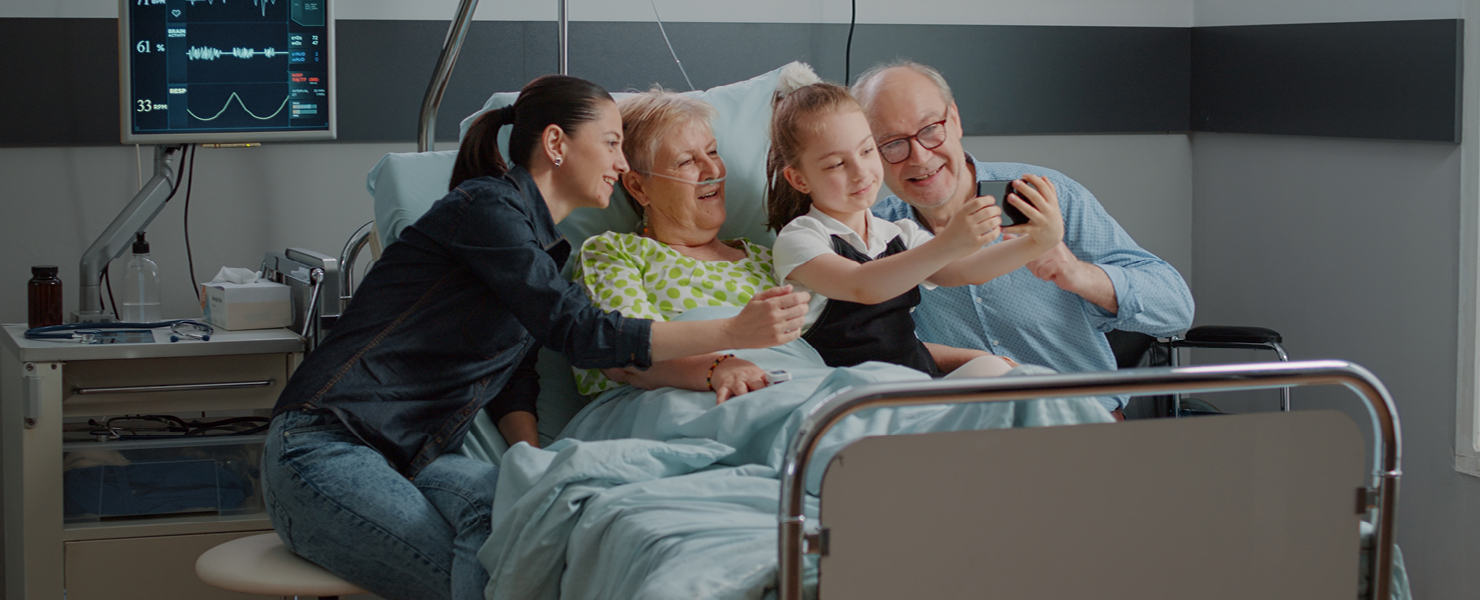 Patient in hospital bed surrounded by family